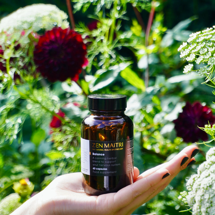Balance Capsules for natural stress support, shown with calming herbs.