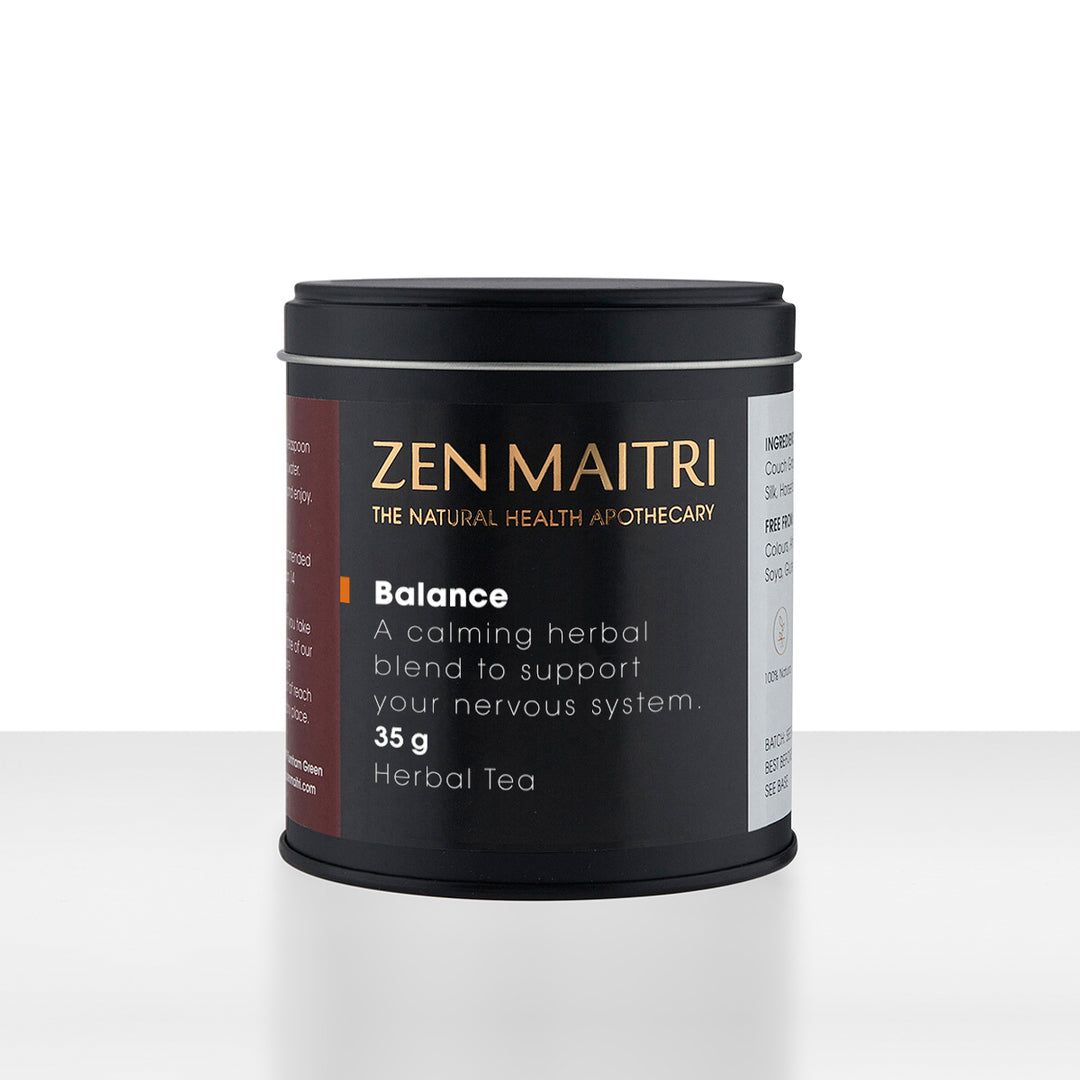 A black cylindrical tin of Zen Maitri Balance herbal tea by The Natural Health Apothecary, set against a clean white background with a subtle reflection.